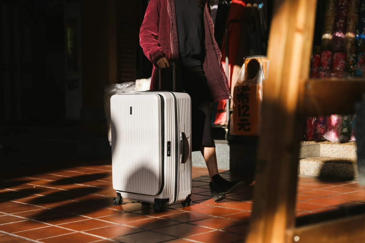 旅客拉著大型行李箱準備出發,示意機場接送可載運大件行李